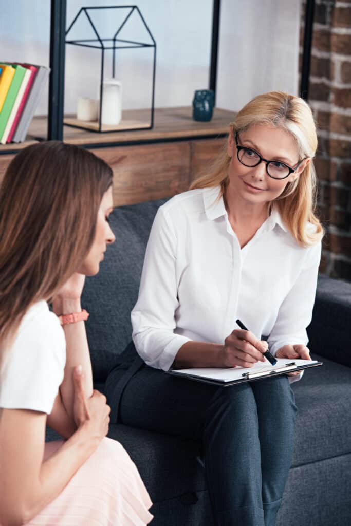 stressed woman sitting on session with female therapist at office